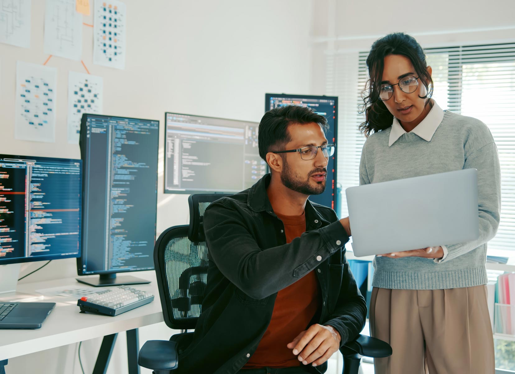 Co-workers look a a laptop