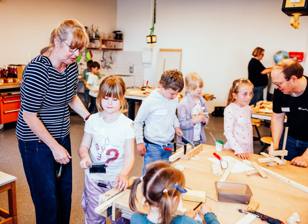 Eine Lehrerin und ihre Schüler*innen in einem Kursraum.